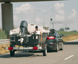 car towing a boat on the highway